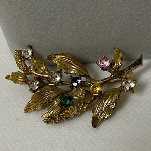 Sterling silver gold plated leaf brooch w 8 rhinestones. Marked “STER PC”.